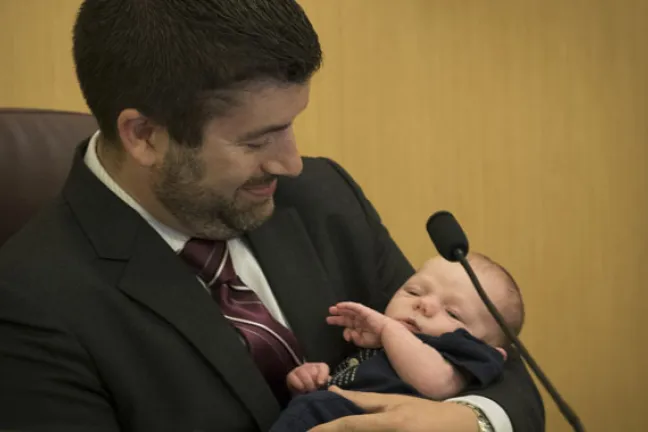 Commissioner Jules Bailey admires his two-week old son, August at Thursday's board meeting