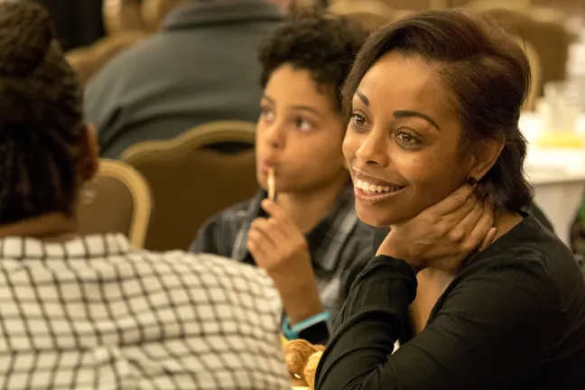 Taneshia Collazo chats with guests. Her nine-year-old son Carter sits next to her.