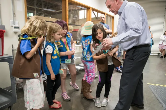 Multnomah County Elections Director Tim Scott (right) shows elections material to a Girl Scouts troop during a May 2018 tour.