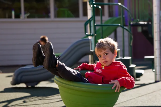 preschooler in cup swing at Menlo Park elementary school