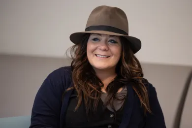 Smiling woman wearing a hat and dark top