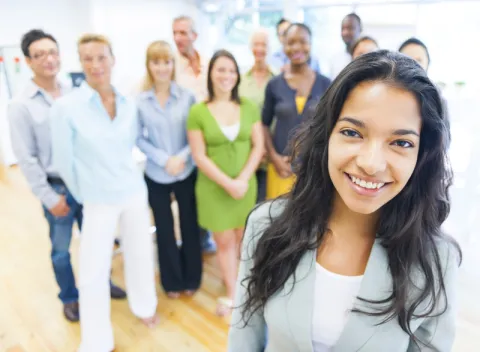 young woman with colleagues standing behind her at a short distance