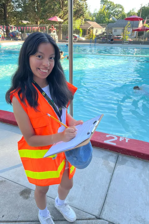 A girl jots notes on a clipboard at Pier Pool.